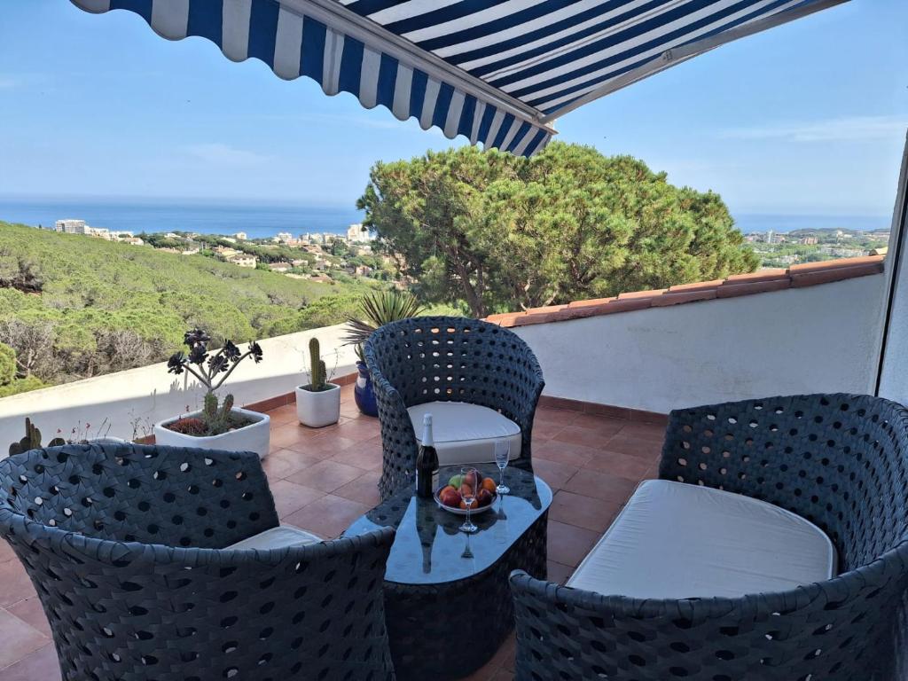 un balcón con 2 sillas y un bol de fruta en Apartment Platja de Aro con piscina y vistas al mar, en Platja d'Aro