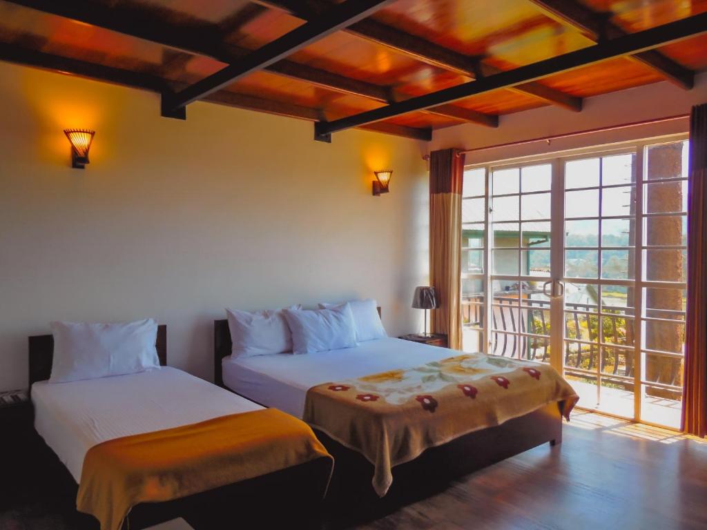 two beds in a room with a balcony at Terrabella - Nuwara Eliya in Nuwara Eliya