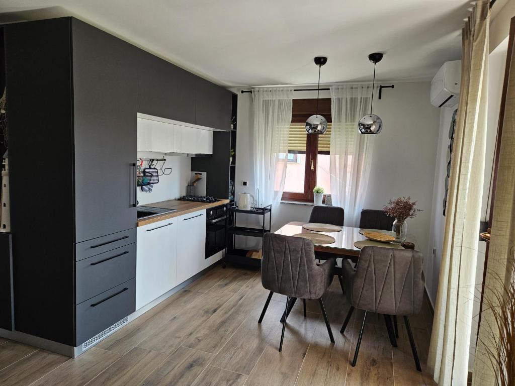 Apartments Frama Poreč - Funtana في فونتانا: مطبخ وغرفة طعام مع طاولة وكراسي