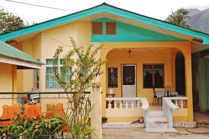 uma pequena casa amarela com um telhado verde em Joy Transient House em Panabo