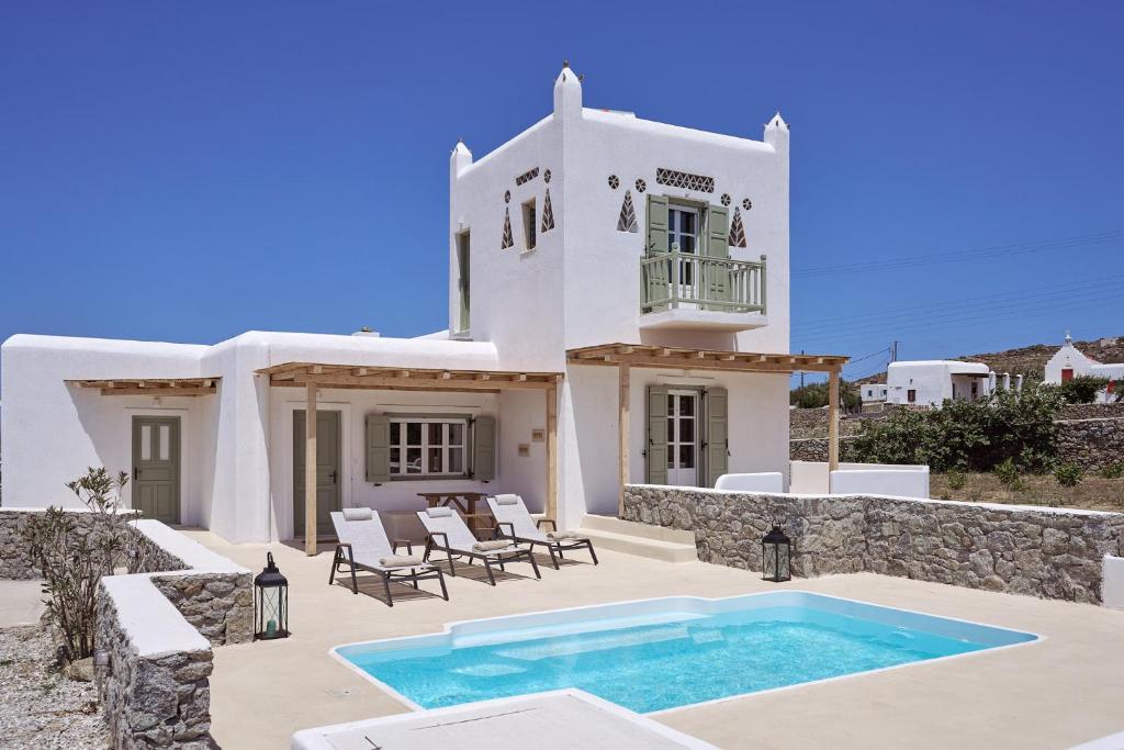 a house with a swimming pool in front of it at Philippi Villa in Mikonos