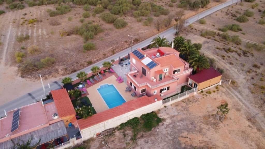 an overhead view of a large pink house with a pool at Villa Paradis Pêra - Quartos para férias in Pêra