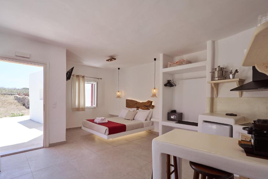 uma sala de estar com uma cama e uma cozinha em Casa Philippi Suites em Míconos