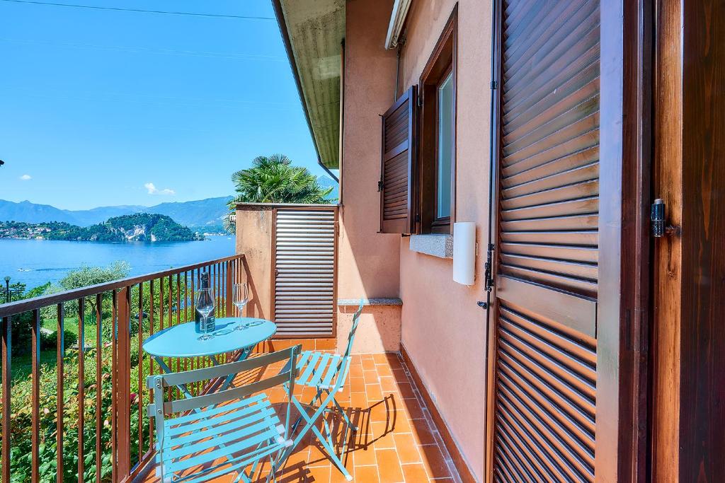 a balcony with a table and chairs and a view of the water at Appartamento Pinus Varenna in Varenna