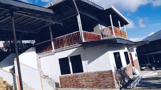 un bâtiment blanc avec un balcon au-dessus dans l'établissement Rama-rama Homestay Kundasang, à Kampong Kundassan