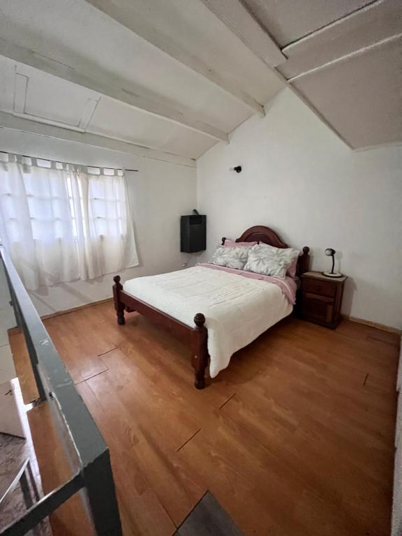 1 dormitorio con 1 cama y suelo de madera en Alquiler en el CENTRO Luz en Río Gallegos