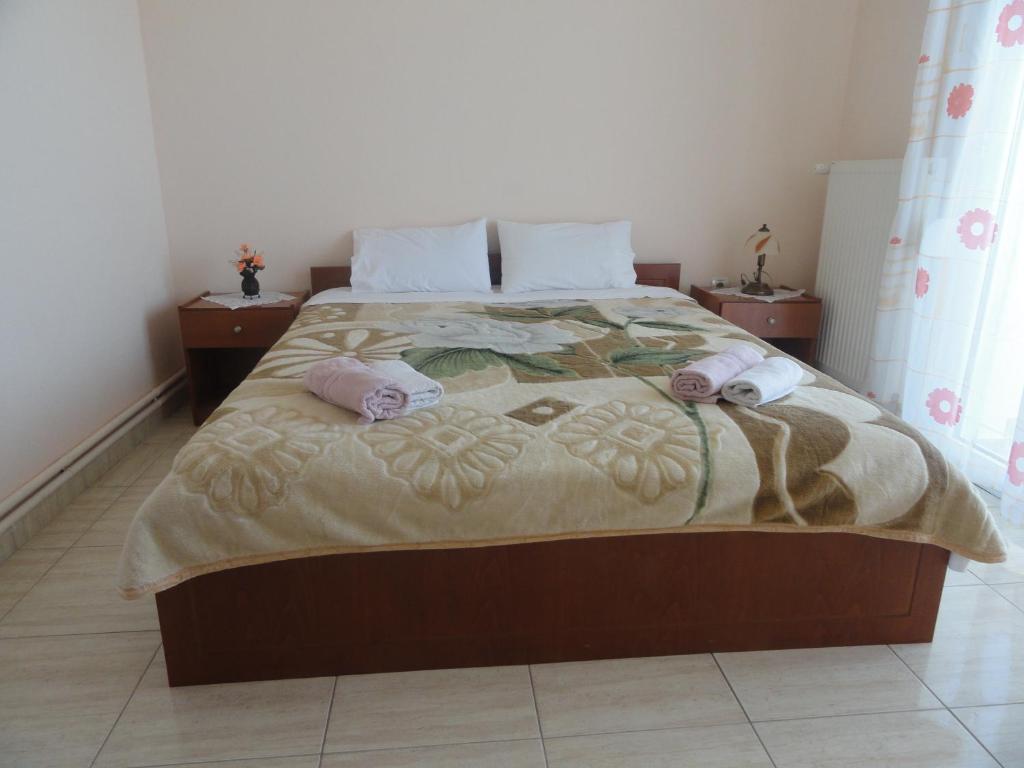 a bedroom with a large bed with two pillows at Pension Delfini in Asprovalta
