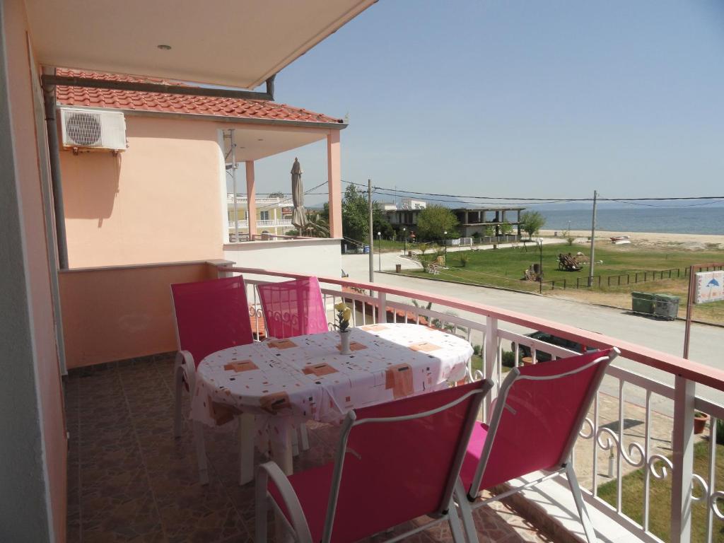 a table and chairs on a balcony with a view of the ocean at Pension Delfini in Asprovalta