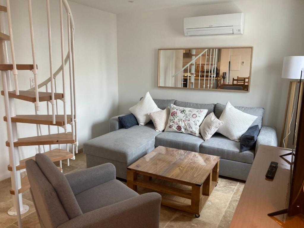 ein Wohnzimmer mit einem Sofa und einem Tisch in der Unterkunft Appartement neuf coeur du village in Saintes-Maries-de-la-Mer
