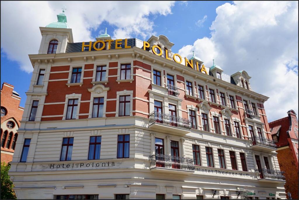 een hotelgebouw met een bord erop bij Hotel Polonia in Toruń