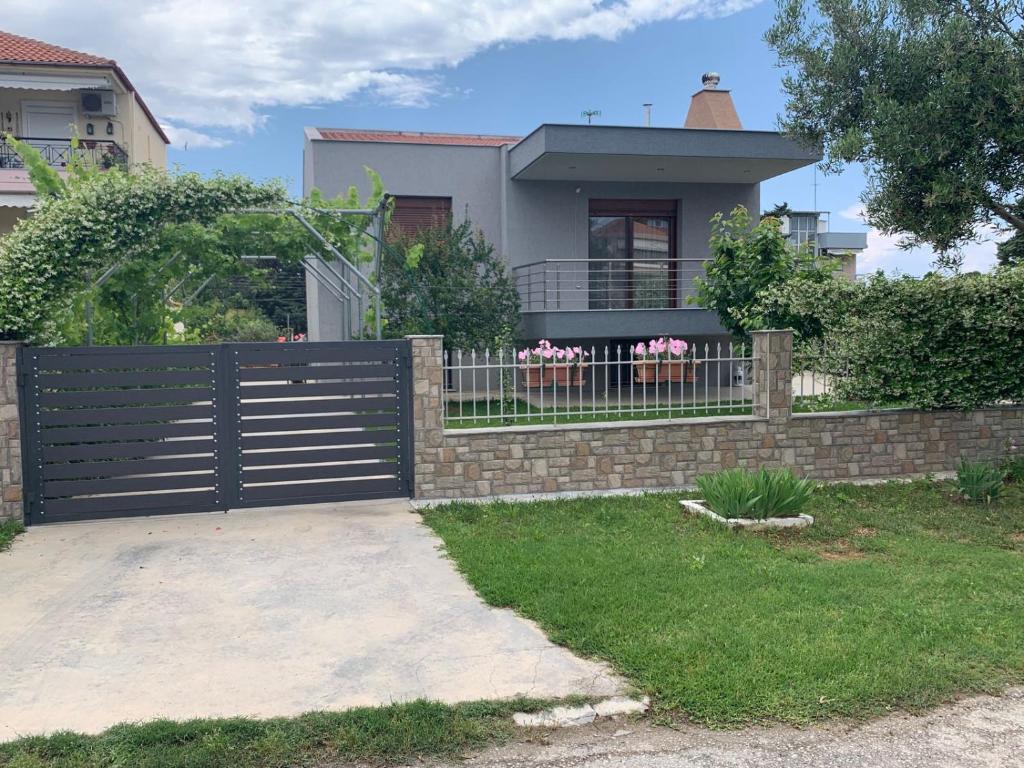 a house with a gate and a fence at Holiday home in Nea Kallikratia in Nea Kalikratia