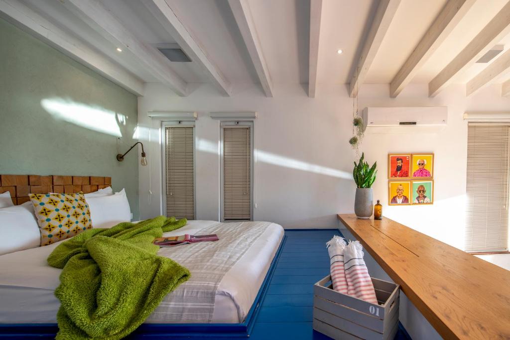 1 dormitorio con 1 cama grande y barra de madera en Adika, en Ma'ale Gamla