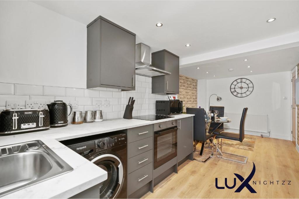 uma cozinha com um lavatório e uma máquina de lavar louça em Luxnightzz - Stylish Boutique 1 Bed Apartment em Gravesend