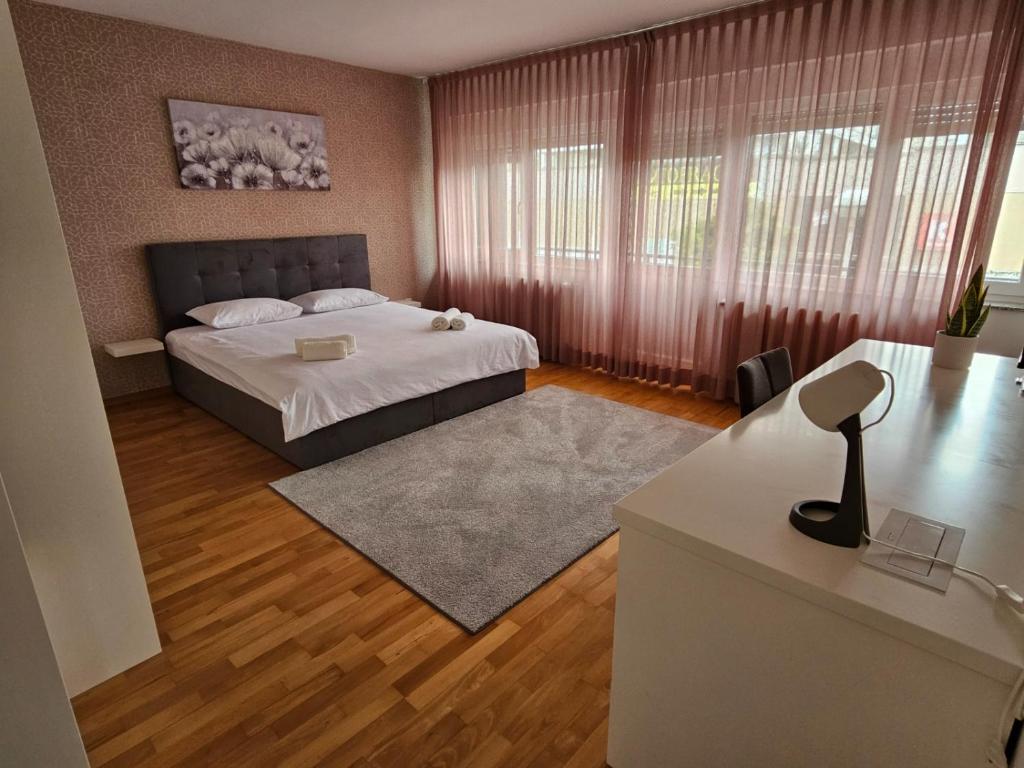 a bedroom with a bed and a desk in it at Comfort Rooms Remiza in Zagreb
