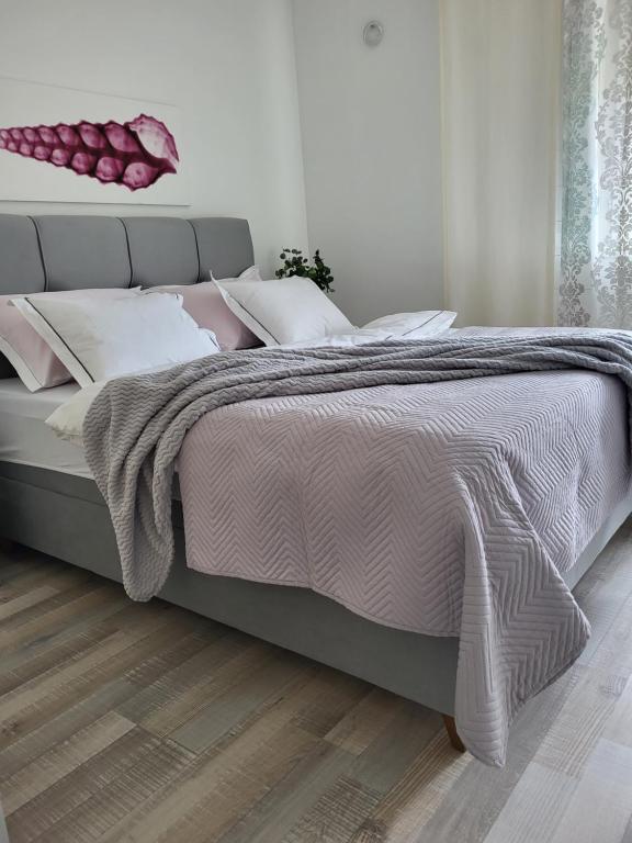 a bedroom with a large bed with pink and white pillows at Split Mari Apartment in Split