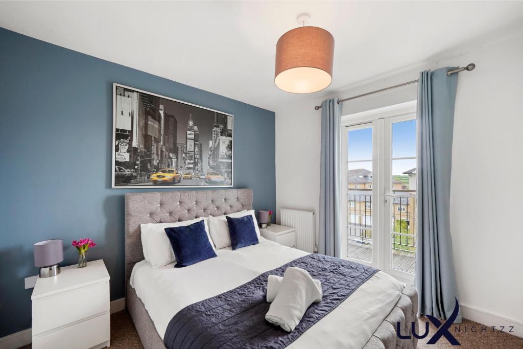 sypialnia z łóżkiem z niebieskimi ścianami i oknem w obiekcie Luxnightzz - Clarendon Heights - Stylish Two-Bedroom Apartment w mieście Colchester