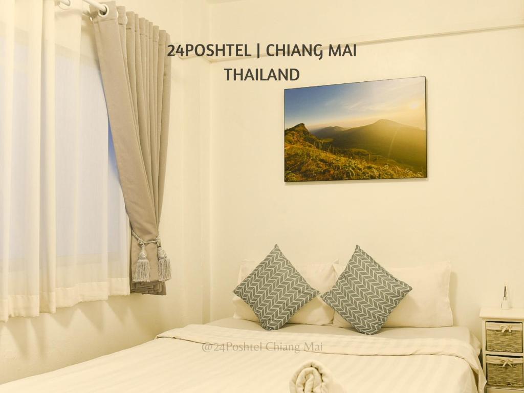 een slaapkamer met een bed en een foto aan de muur bij 24 Poshtel Chiangmai in Chiang Mai