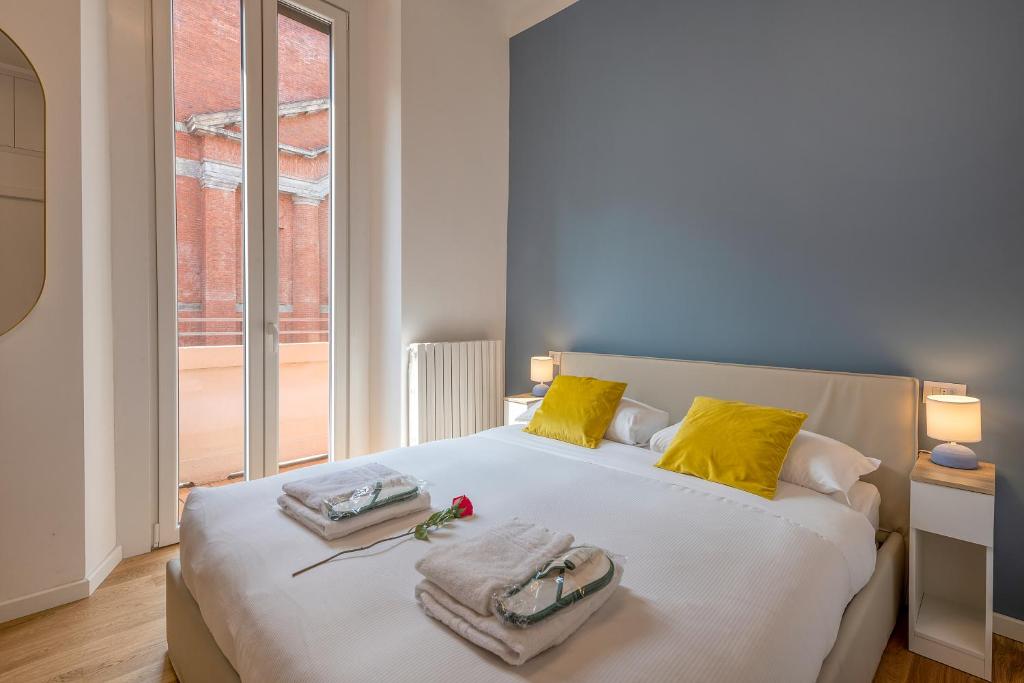 um quarto com uma grande cama branca com almofadas amarelas em BnButler - Sebenico, 28 - Nuovissimo Appartamento in Isola em Milão