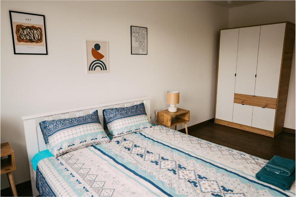 een slaapkamer met een bed met blauwe en witte kussens bij Klicakn in Subotica