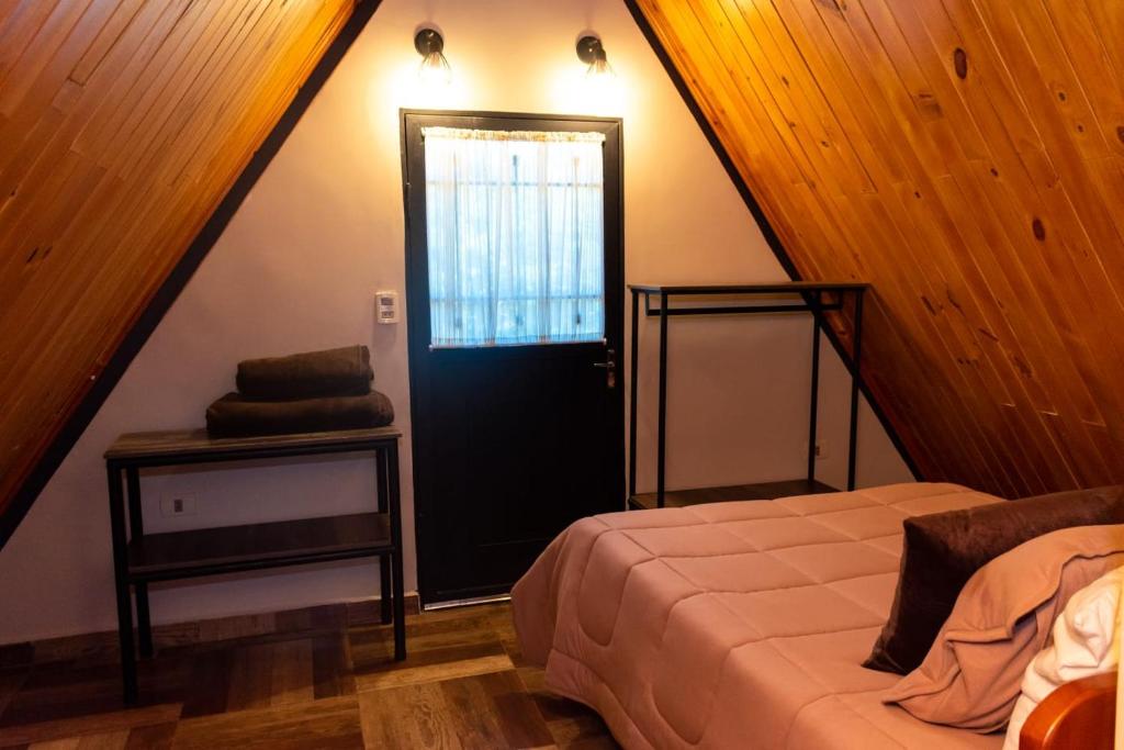 Schlafzimmer mit einem Bett und einer schwarzen Tür in der Unterkunft Campo Verde Bungalows in Capitán Miranda