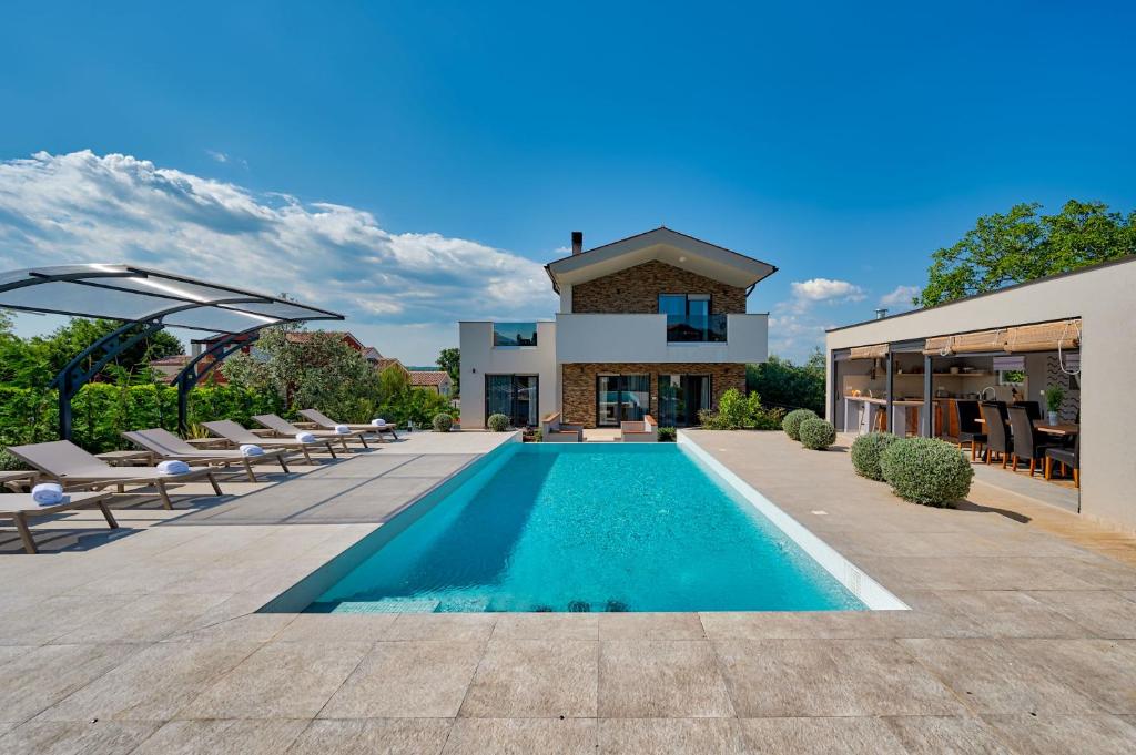 eine Villa mit einem Pool vor einem Haus in der Unterkunft Villa Tami in Hreljići