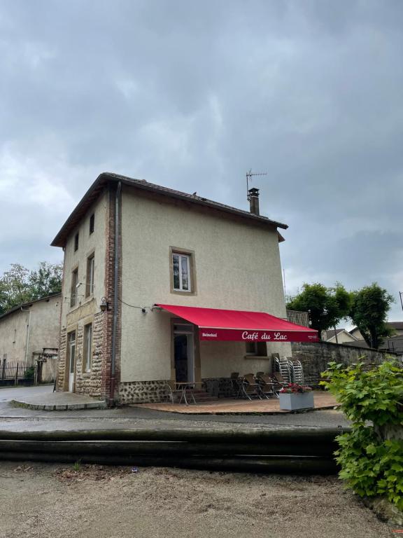 een gebouw met een rode luifel ervoor bij Café du lac in Manthes