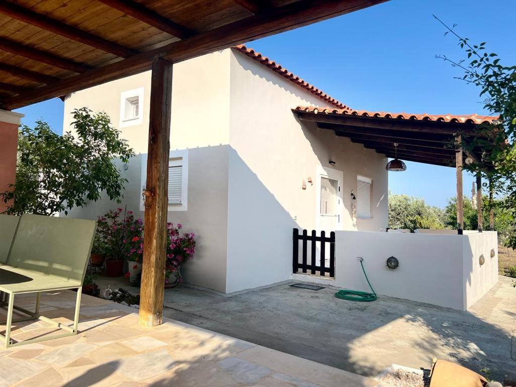 a white house with a fence and a chair at Nepis Cottage, GcollectionGr in Ermioni