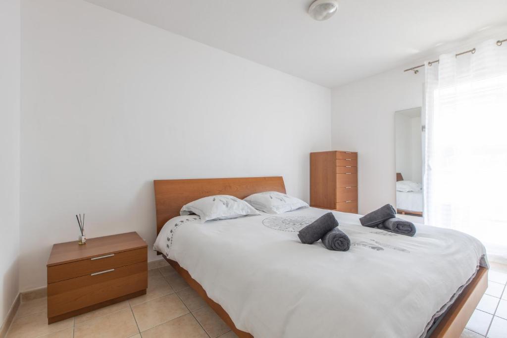 um quarto branco com uma cama grande e uma janela em Riviera Home em Beausoleil