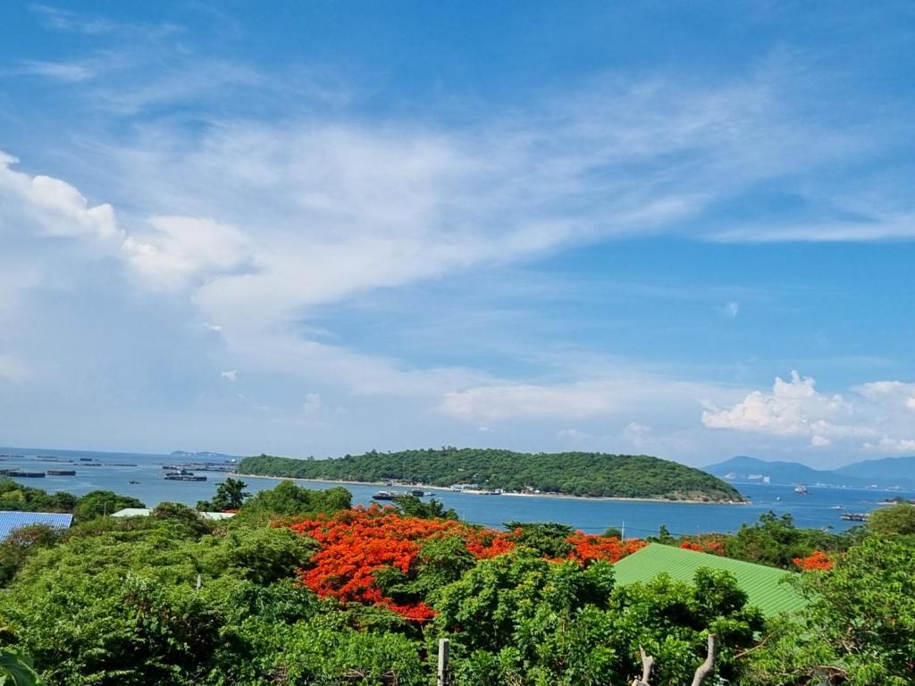 una vista de un cuerpo de agua con árboles y flores en Sawasdee Sichang Resort en Ban Tha Thewawong