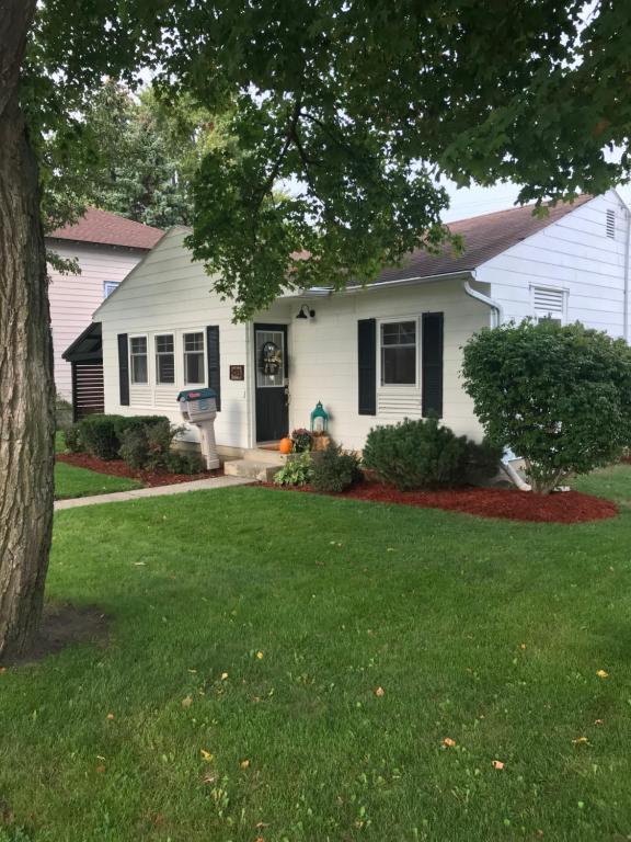 a white house with a tree in the yard at Cheerful 2 Bedroom Cottage on 5th in Decatur