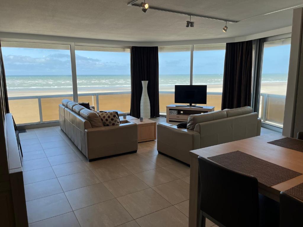 ein Wohnzimmer mit Blick auf den Strand in der Unterkunft Zeedijk Heist Hoekappartement Probitas G6 in Knokke-Heist