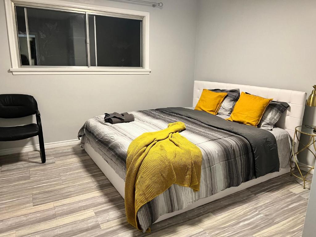 a bedroom with a bed with yellow pillows and a window at Spacious room with TV, Wi-Fi, Netflix, Parking in Edmonton