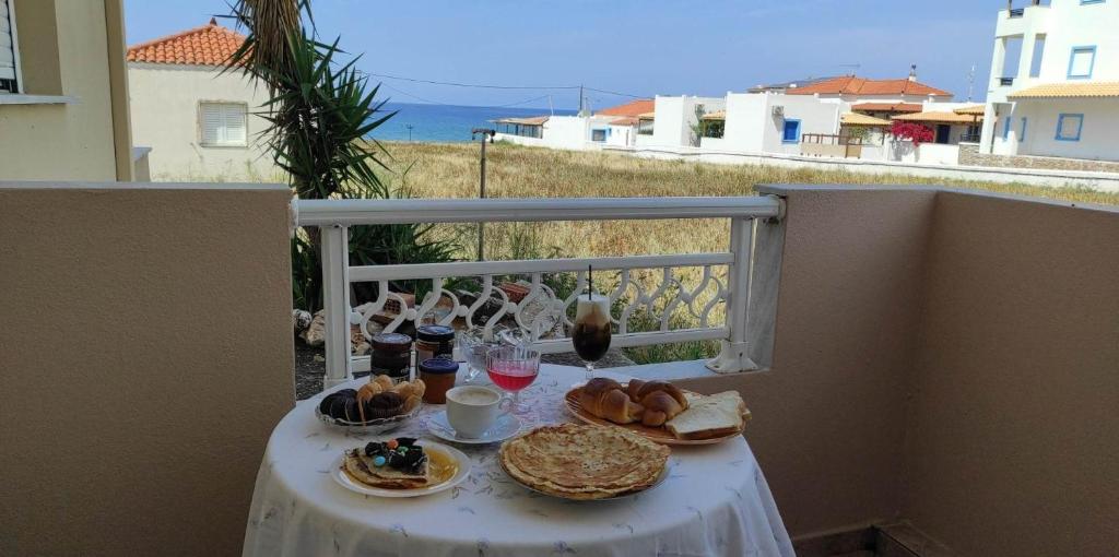 a table with food and drinks on a balcony at Toulas House in Elíka