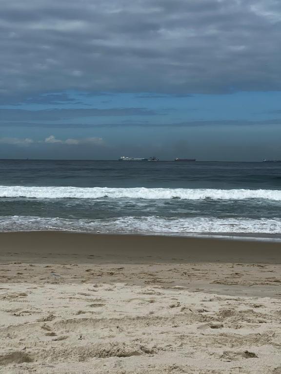 una playa de arena con olas en el océano en A 7 jdjsjwjxjsj en Rancagua