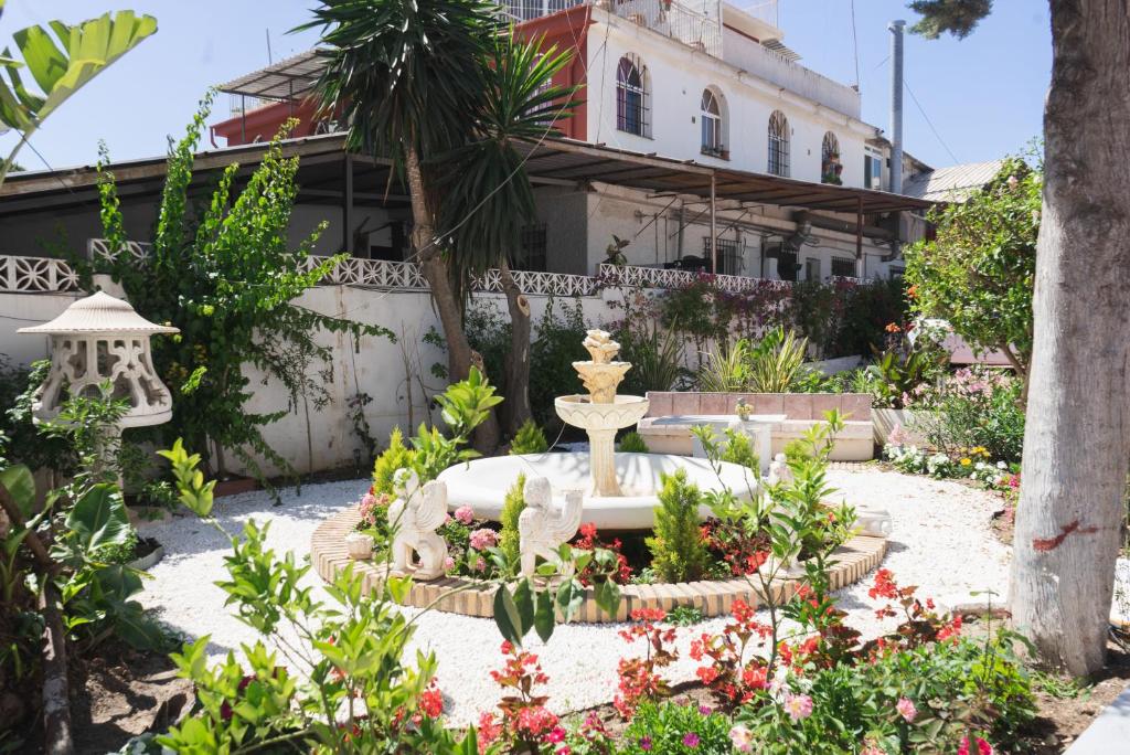 a garden with a fountain in front of a building at Rancho Grande in Marbella