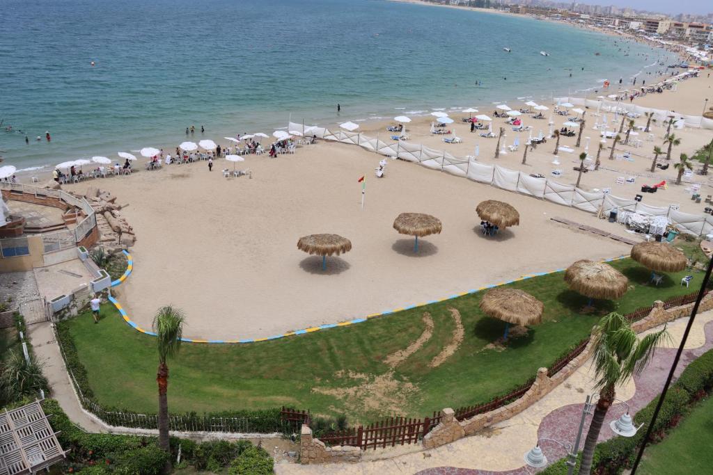 亞歷山大的住宿－Mamoura Private Beach, Exclusive Luxury & Comfort，海滩上有人和遮阳伞海滩