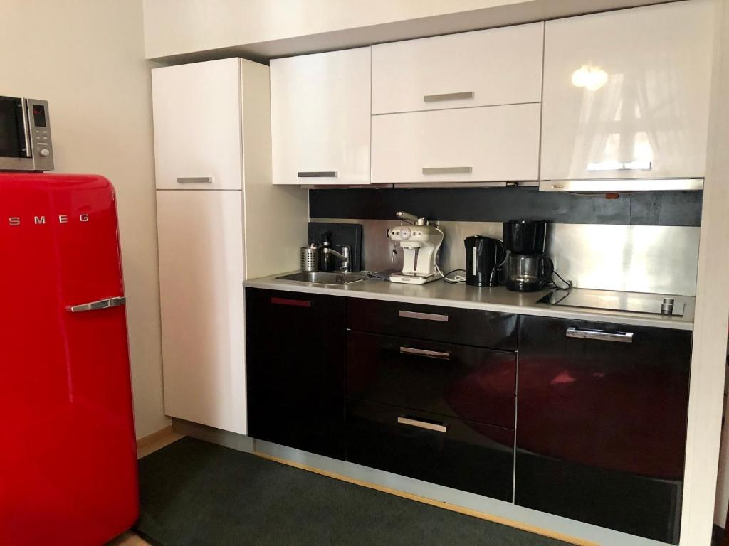 a kitchen with a red refrigerator next to a counter at Sweet home 40 City Center Punavuori in Helsinki