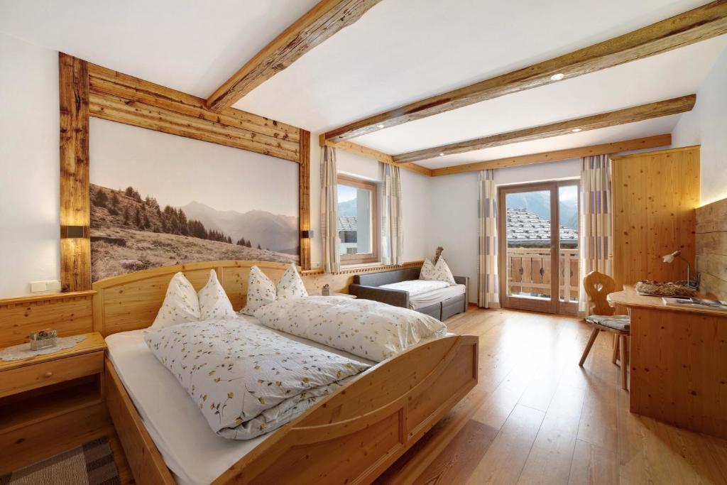 a bedroom with a bed and a large window at Oberhof Apt Ilmenspitz in Larcher