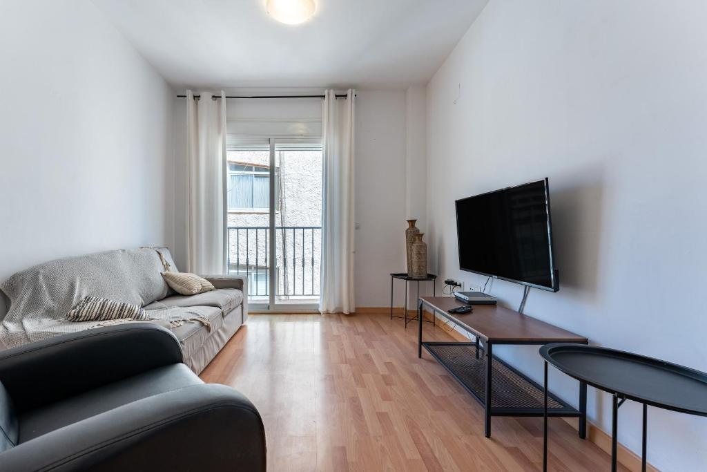 een woonkamer met een bank, een tv en een tafel bij Apartamento Postal in Fuengirola