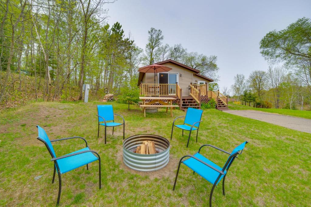a group of chairs sitting in front of a cabin at Lakefront Wisconsin Home with Boat Dock and Fire Pit! 