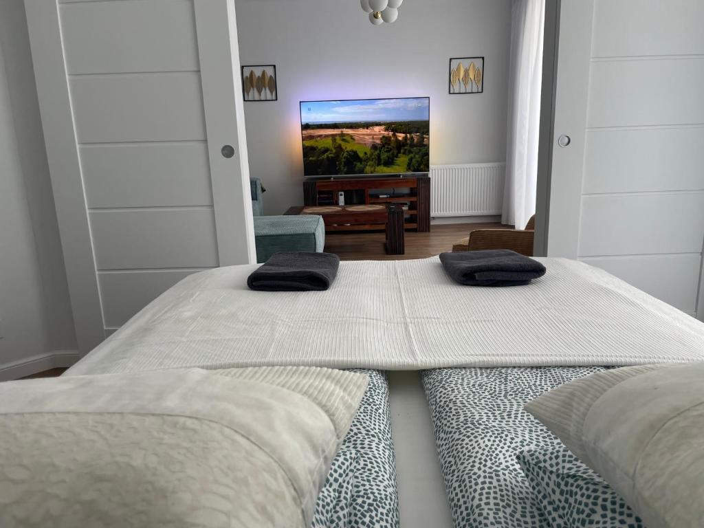a bedroom with two beds and a flat screen tv at Apartament 32 NOWA WIEJSKA Olecko Mazury Garbate in Olecko