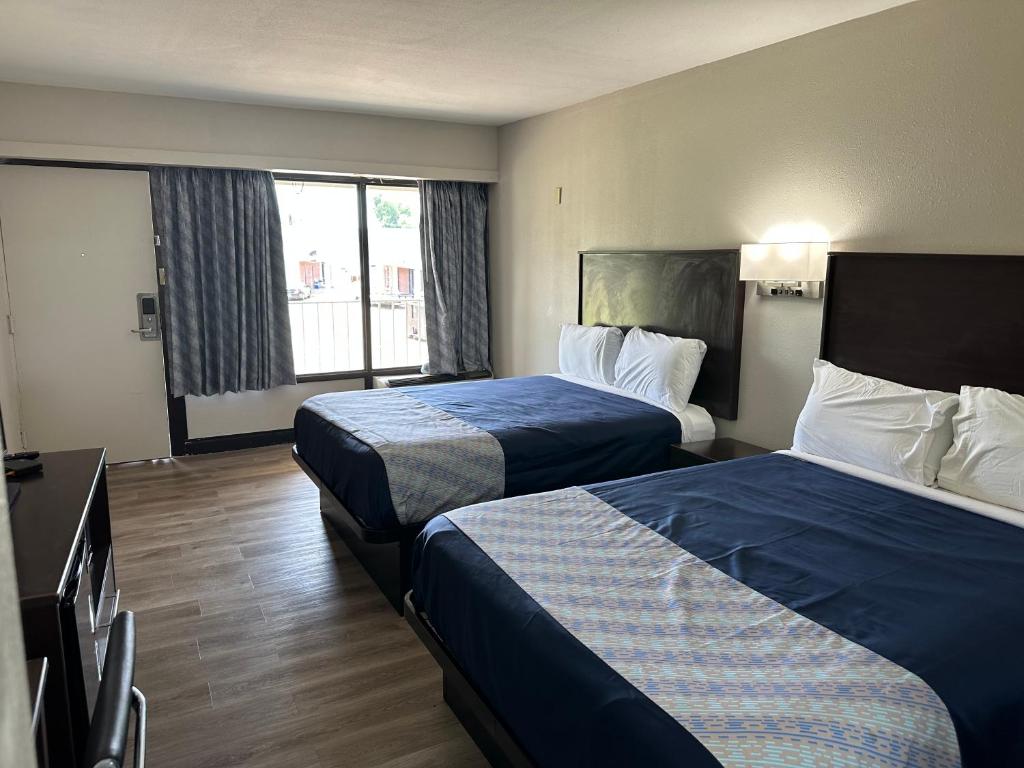 ein Hotelzimmer mit 2 Betten und einem Fenster in der Unterkunft Oakwood Inn in Oakdale