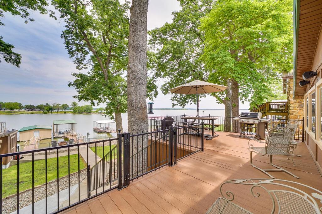 um deque com uma mesa, cadeiras e um guarda-sol em Pet-Friendly Grove Vacation Rental with Boat Dock! em Grove
