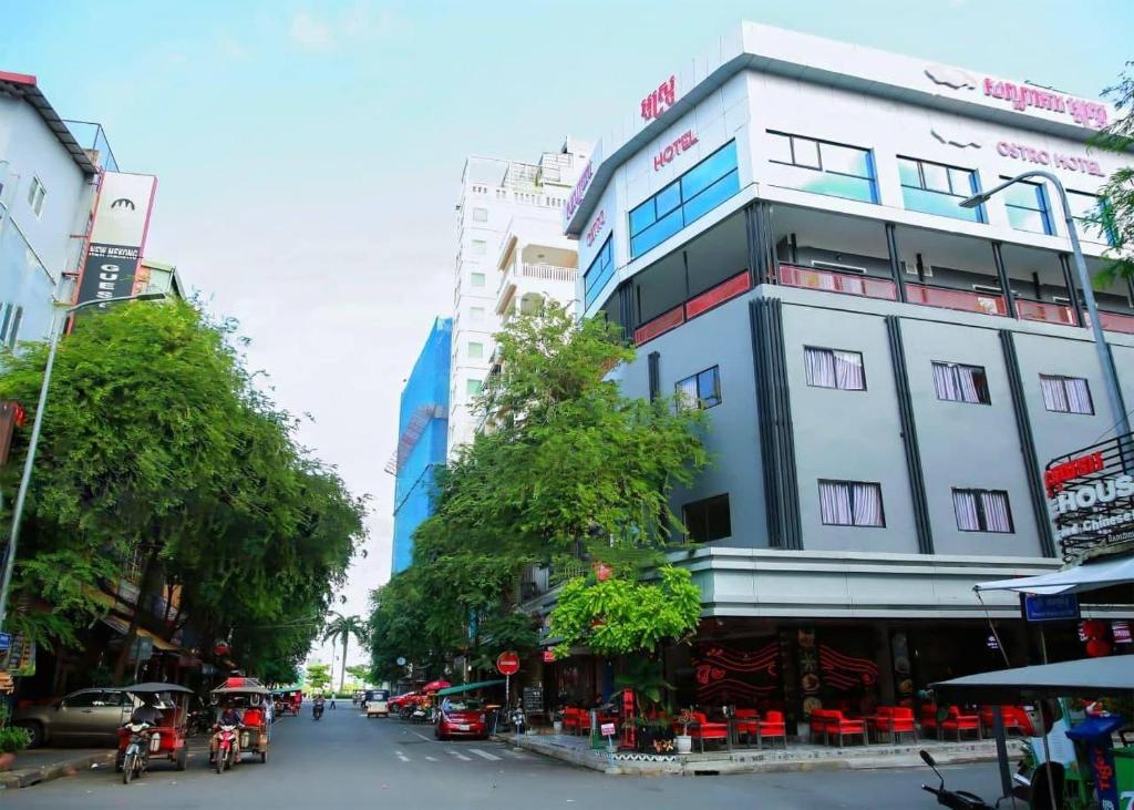 Ostro Hotel في بنوم بنه: مبنى أبيض طويل على شارع المدينة