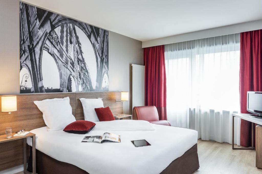a hotel room with a large bed and a tv at Aparthotel Adagio Birmingham City Centre in Birmingham