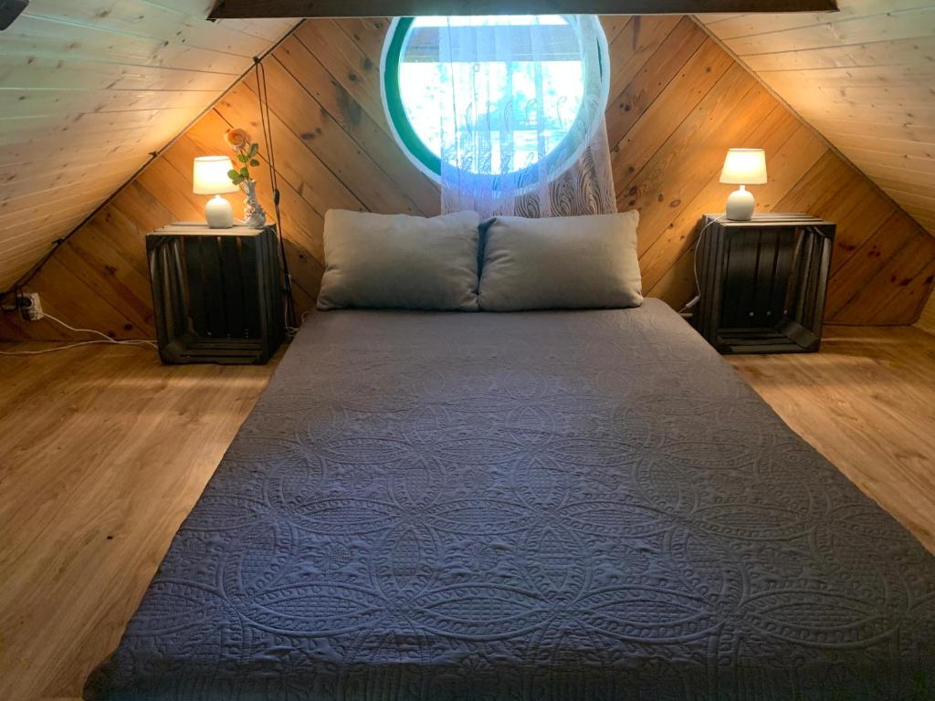 a bed in a room with a window at Agroturystyka Leśny Zakątek - Domek z sauną in Ożarów