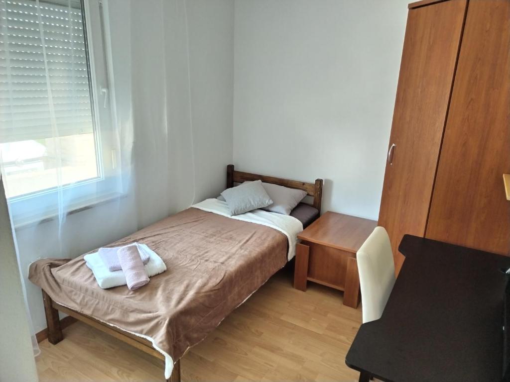 um pequeno quarto com uma cama e uma mesa em Apartman Grbić em Vodnjan
