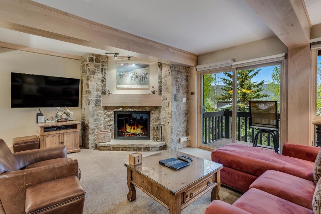 a living room with a couch and a fireplace at Interlude Condominiums 2-Bedroom Unit 202 in Snowmass Village