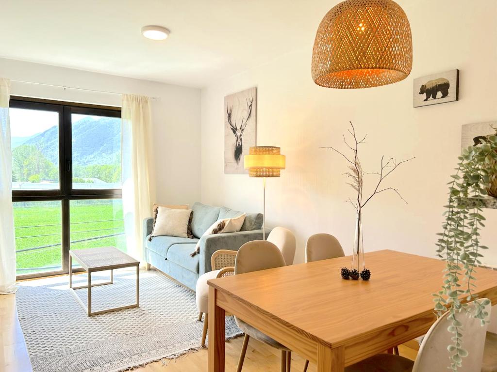 un soggiorno con un tavolo e un divano blu di Apartament de disseny rústic amb vistes by RURAL D'ÀNEU a Esterri d'Àneu