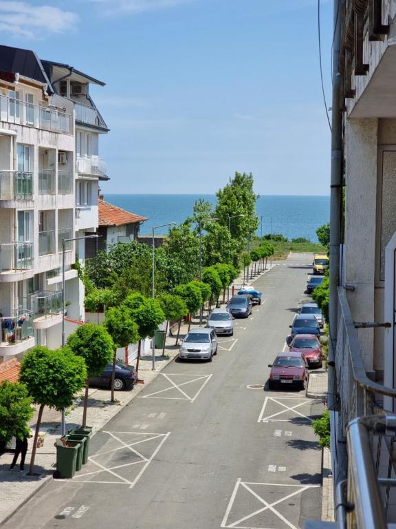 een uitzicht op een straat met auto's geparkeerd op een parkeerplaats bij Стаи за гости Мистрал in Primorsko